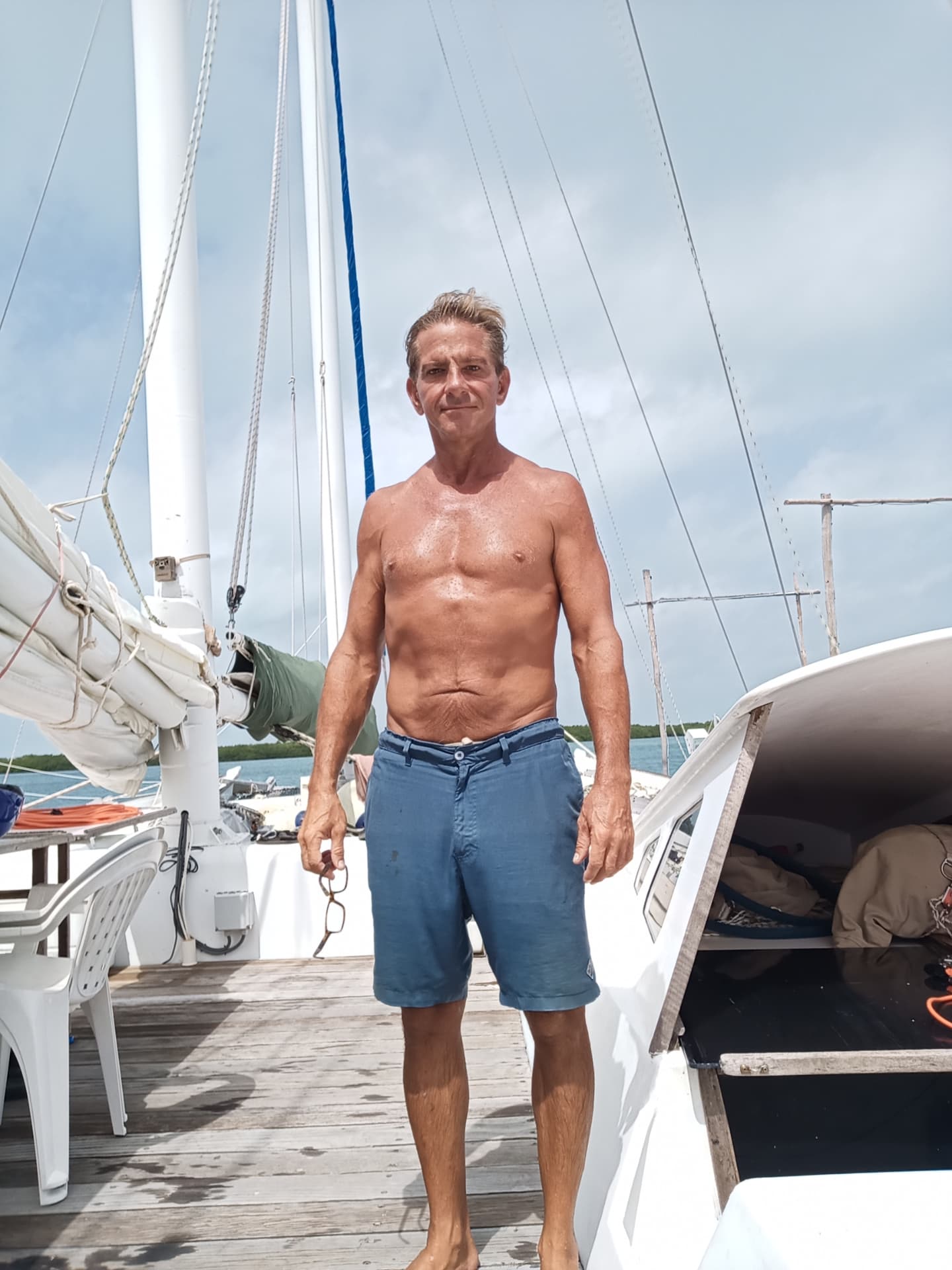David standing healthy on a sailboat in July 2024, five months after the February hospital stay